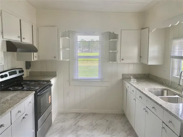 a kitchen with a sink stove and cabinets