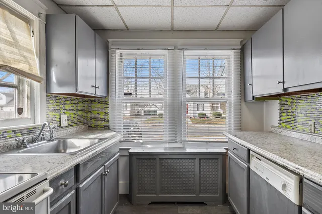a kitchen with granite countertop a refrigerator and a sink