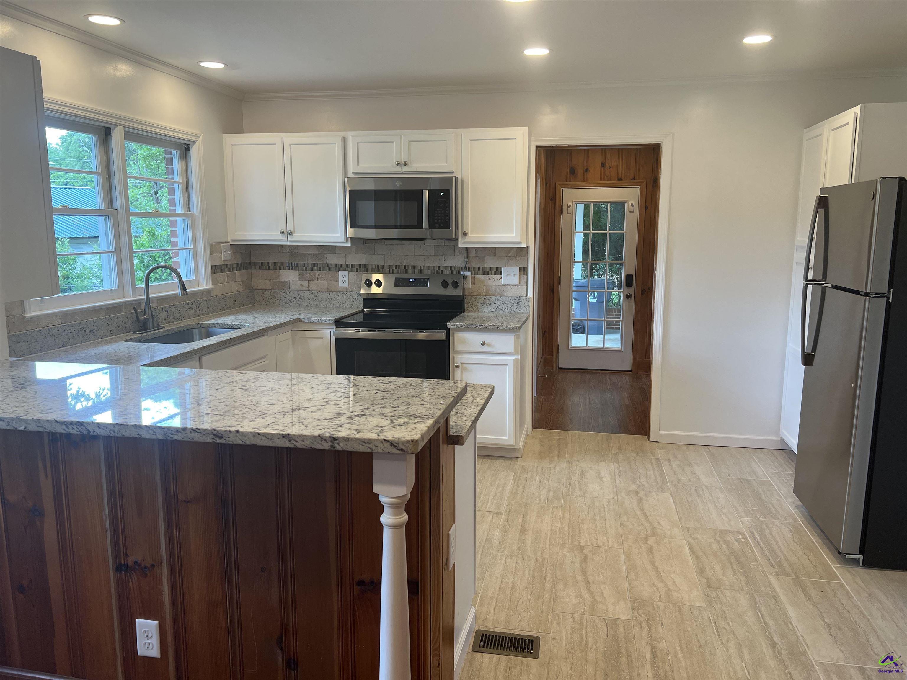 145 South 2nd Street Cochran, GA 31014 - Photo 2 of 24 a kitchen with stainless steel appliances granite countertop a refrigerator and a sink