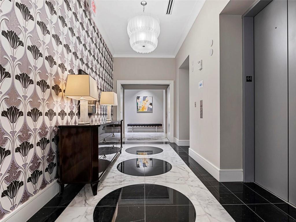 3376 Peachtree Road Northeast, Unit 44B Atlanta, GA 30326 - Photo 44 of 58 a hallway with a table and a fireplace