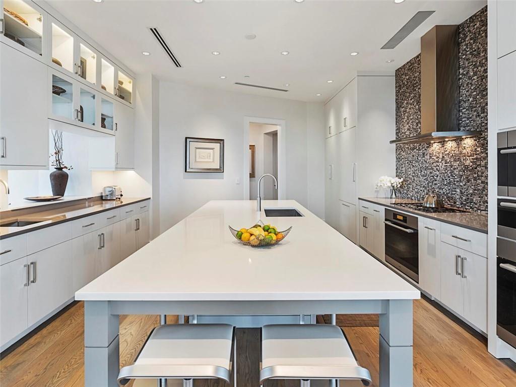 3376 Peachtree Road Northeast, Unit 44B Atlanta, GA 30326 - Photo 10 of 58 a kitchen with stainless steel appliances a kitchen island a stove a table and chairs in it