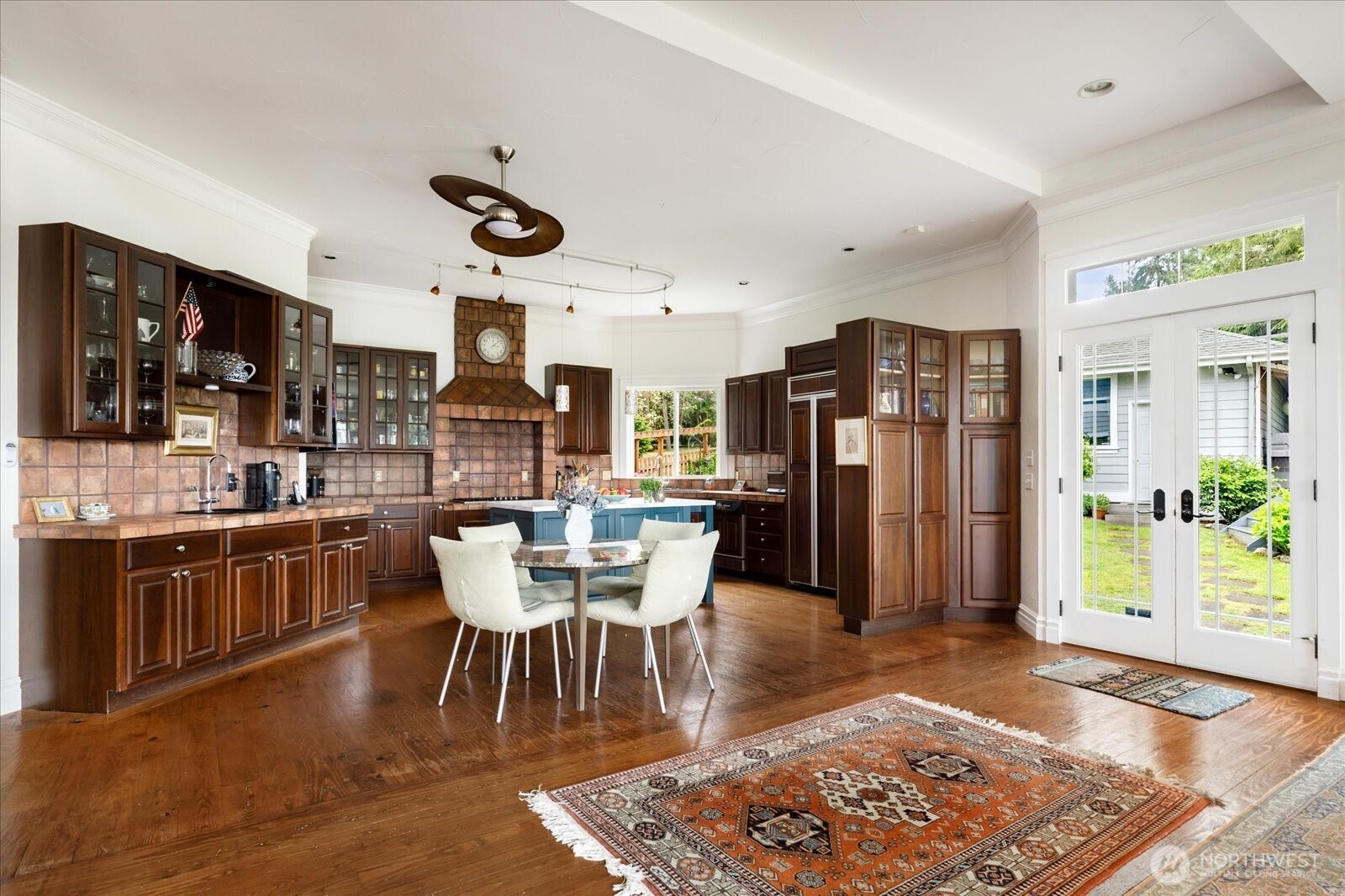 5427 Bayview Road Langley, WA 98260 - Photo 12 of 40 a dining room with stainless steel appliances granite countertop a couch wooden floor a dining table and chairs