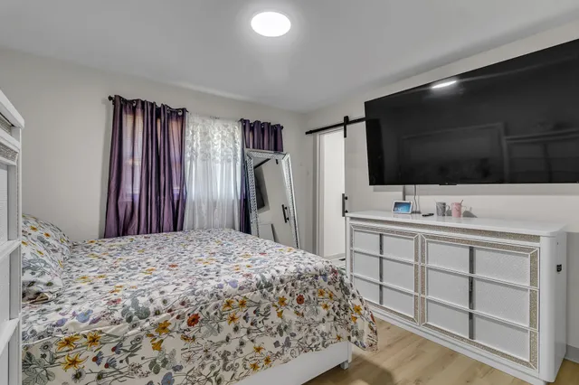 a large bedroom with a bed and a flat screen tv