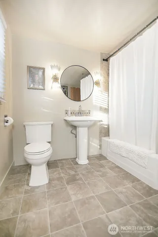 a bathroom with a toilet a sink and a mirror