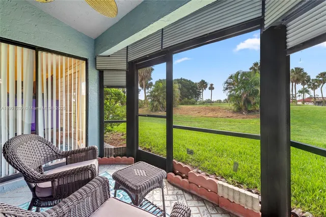 a living room with large windows and a table