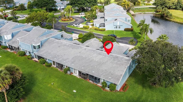 an aerial view of a house with a garden and lake view