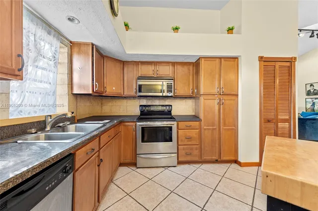 a kitchen with stainless steel appliances granite countertop a stove a sink and a microwave