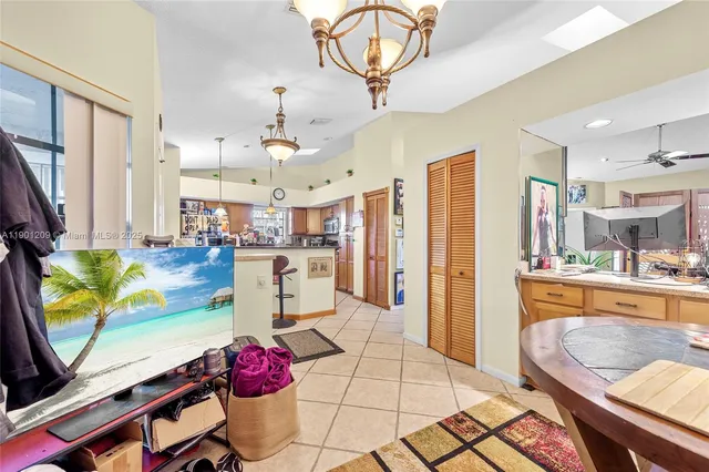 a very nice looking open kitchen with stainless steel appliances granite countertop a stove a refrigerator a oven a dining table and chairs with wooden floor