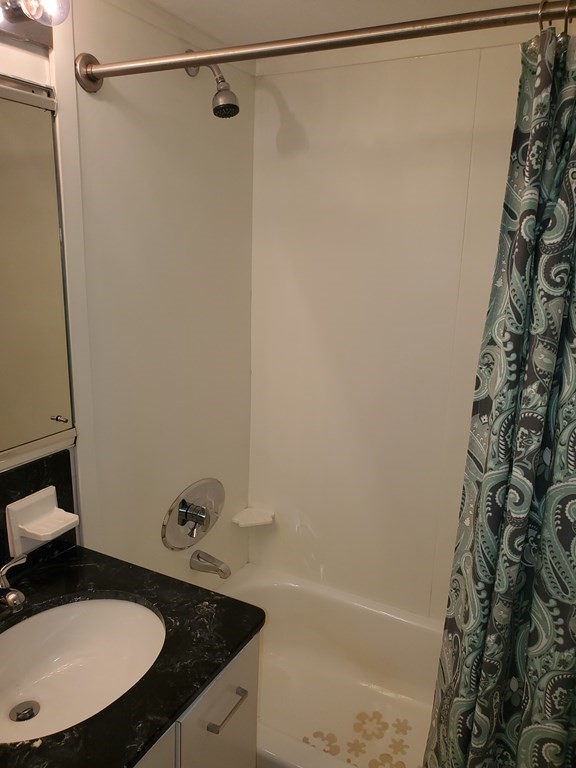 2 Hawthorne Place, Unit 7B Boston, MA 02114 - Photo 8 of 11 a bathroom with a sink and a mirror