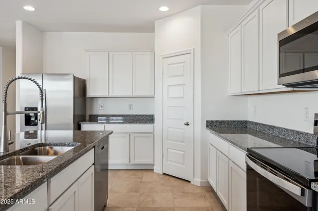 a kitchen with granite countertop a sink stove and refrigerator