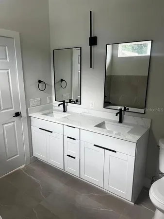 a bathroom with a sink toilet and mirror
