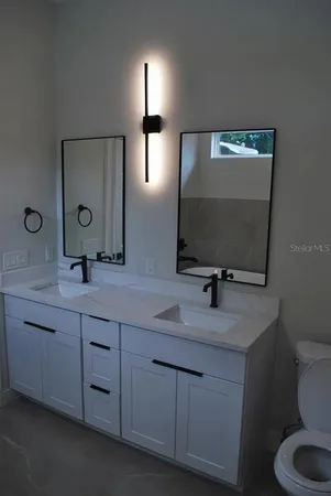 a bathroom with a double vanity sink and a mirror