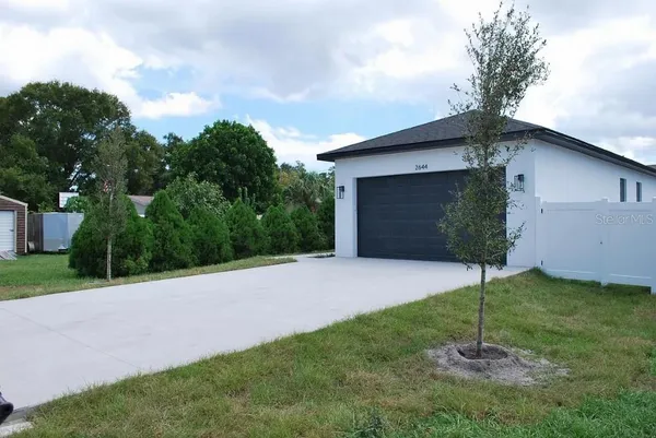 a house is sitting in middle od the grass