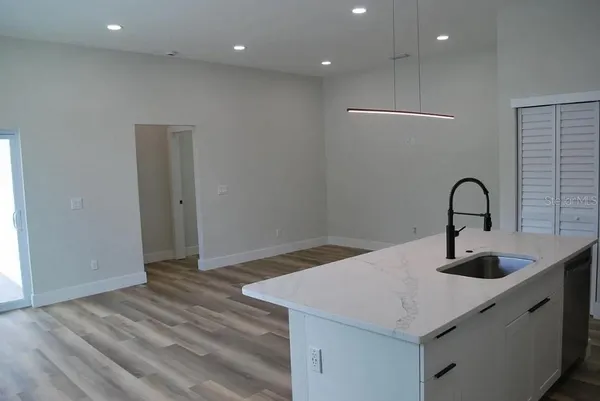a kitchen with a sink and wooden floor