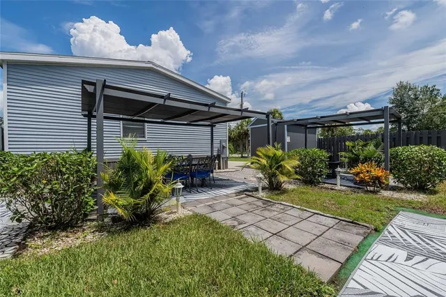 a view of a house with backyard and sitting area