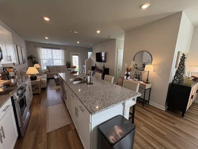 a large kitchen with stainless steel appliances granite countertop a lot of counter space and wooden floor