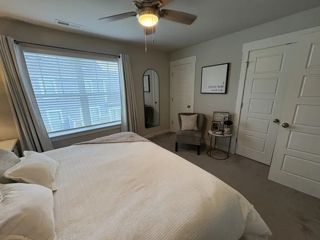 a bedroom with a bed a table and chair