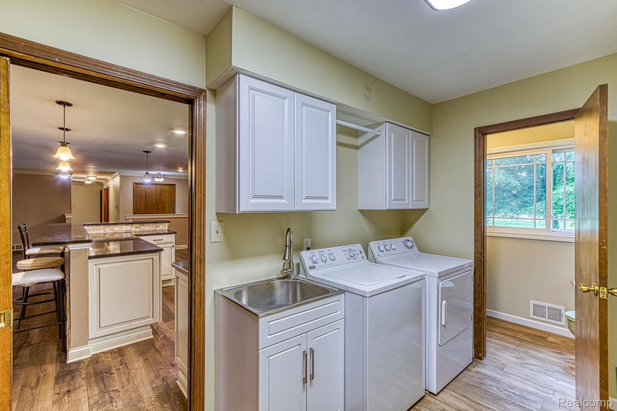 12012 Belle River Road Memphis, MI 48041 - Photo 17 of 41 Laundry room with cabinet space, washing machine and clothes dryer, and dark wood-type flooring