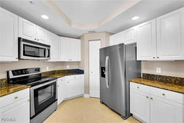 a view of a kitchen with refrigerator and cabinet