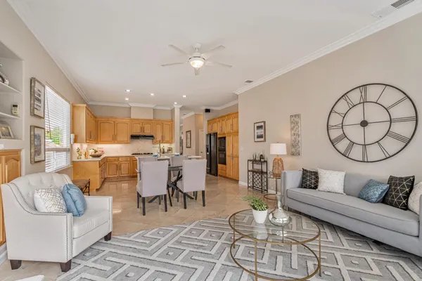a living room with furniture kitchen view and a large window