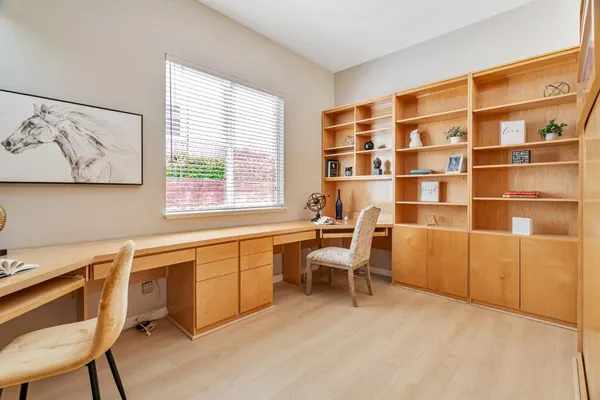a view of a workspace with furniture and a window