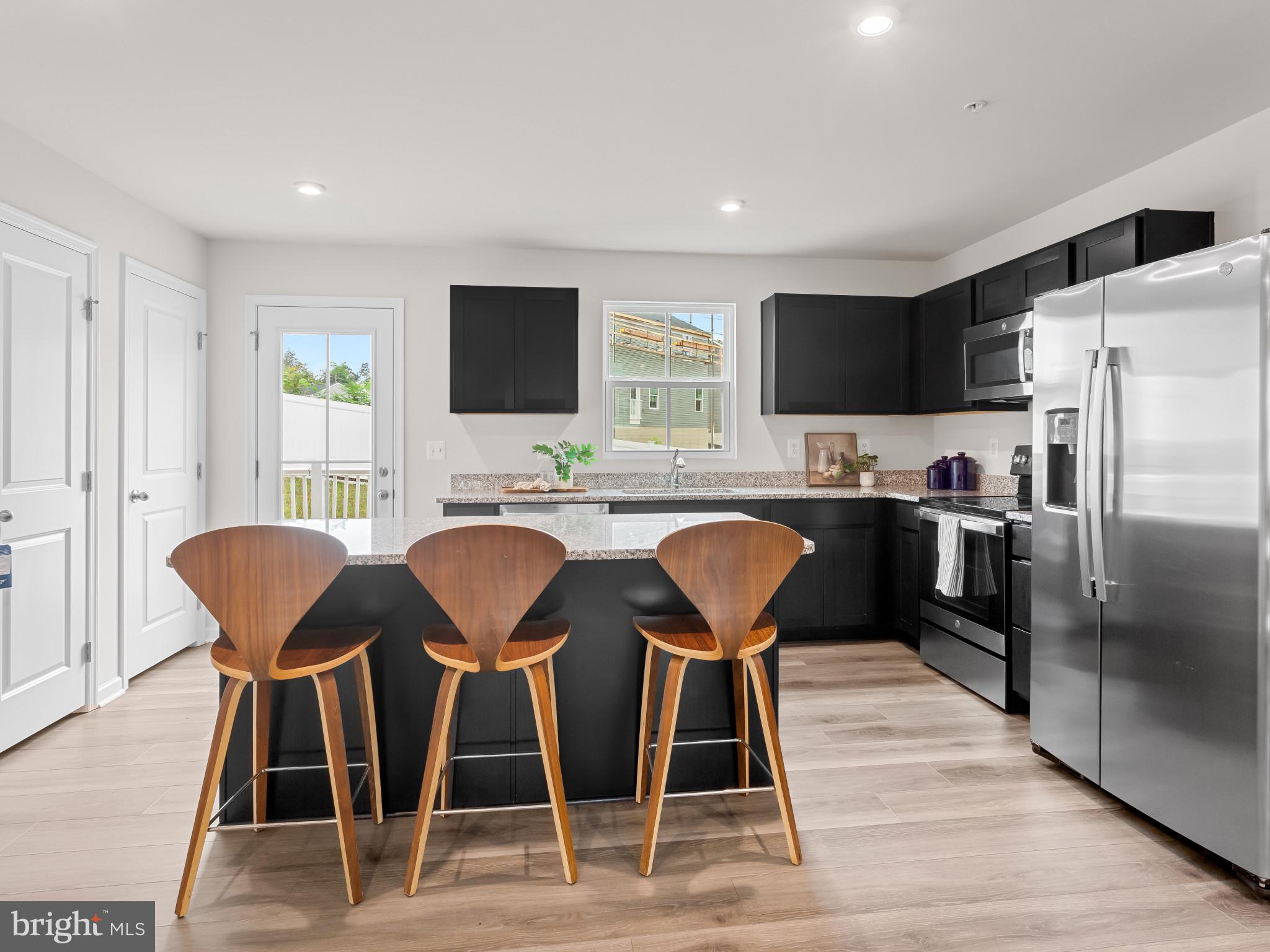 5505 Vergo Road Capitol Heights, MD 20743 - Photo 7 of 42 a kitchen with stainless steel appliances granite countertop a dining table chairs refrigerator and microwave
