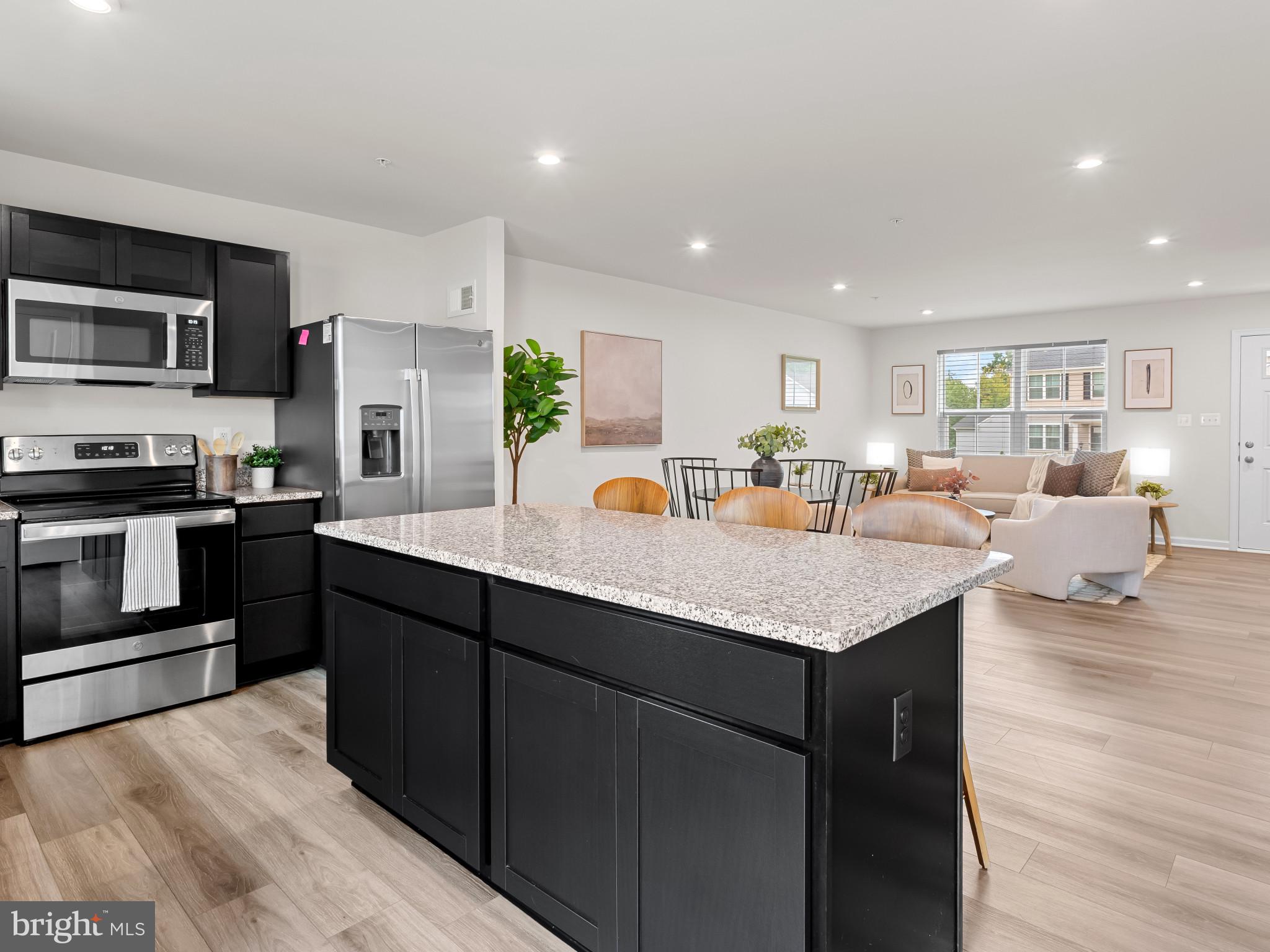 5505 Vergo Road Capitol Heights, MD 20743 - Photo 10 of 42 a living room with stainless steel appliances granite countertop a sink dishwasher a refrigerator and a dining table with wooden floor