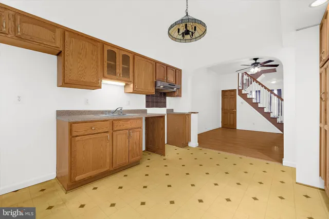 a kitchen with a refrigerator a stove top oven and a sink