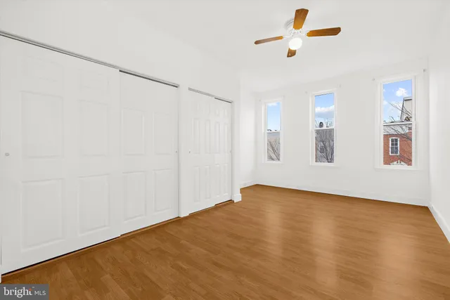 a view of a livingroom with wooden floor and a ceiling fan