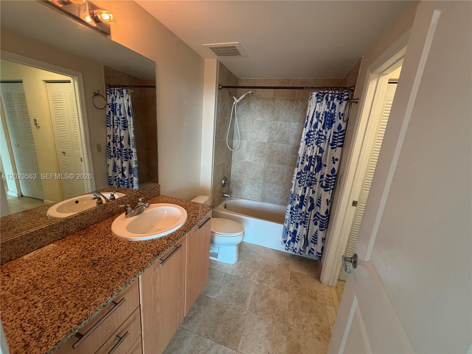 2021 Southwest 3rd Avenue, Unit 902 Miami, FL 33129 - Photo 8 of 14 a bathroom with a granite countertop sink a mirror a vanity and a shower