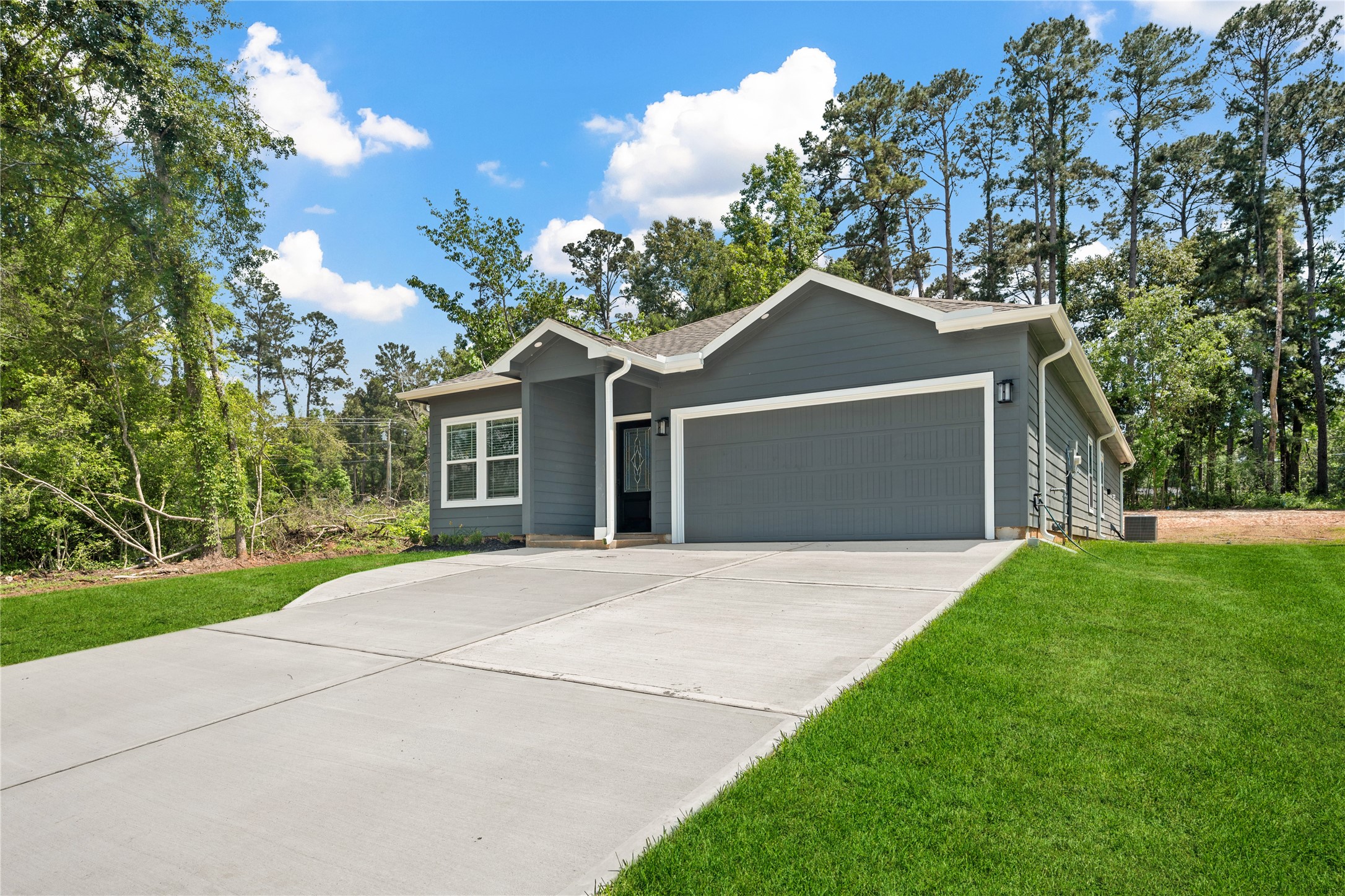 139 Popular Street Onalaska, TX 77360 - Photo 1 of 24 a front view of a house with a yard and garage