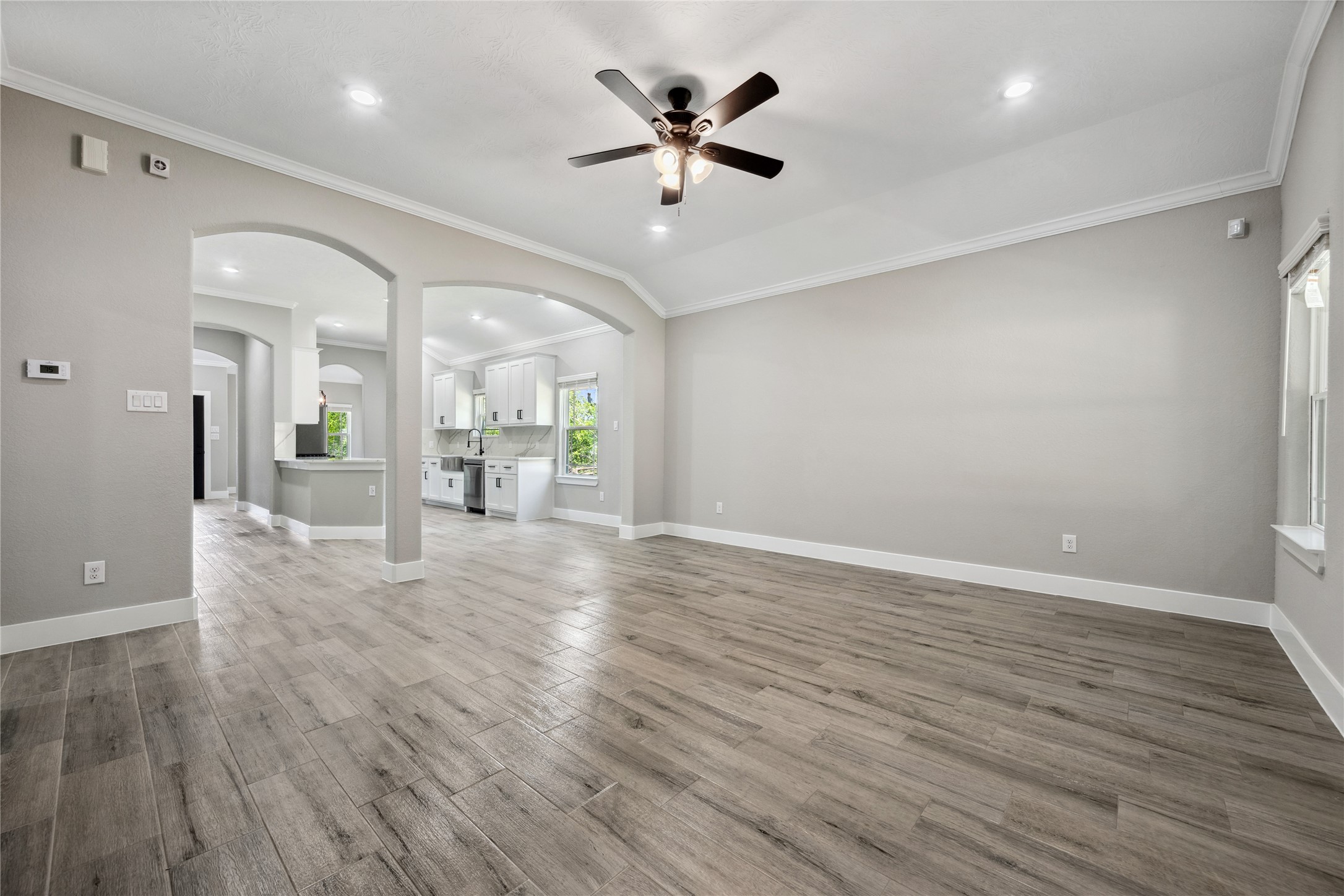139 Popular Street Onalaska, TX 77360 - Photo 8 of 24 an empty room with wooden floor and a ceiling fan