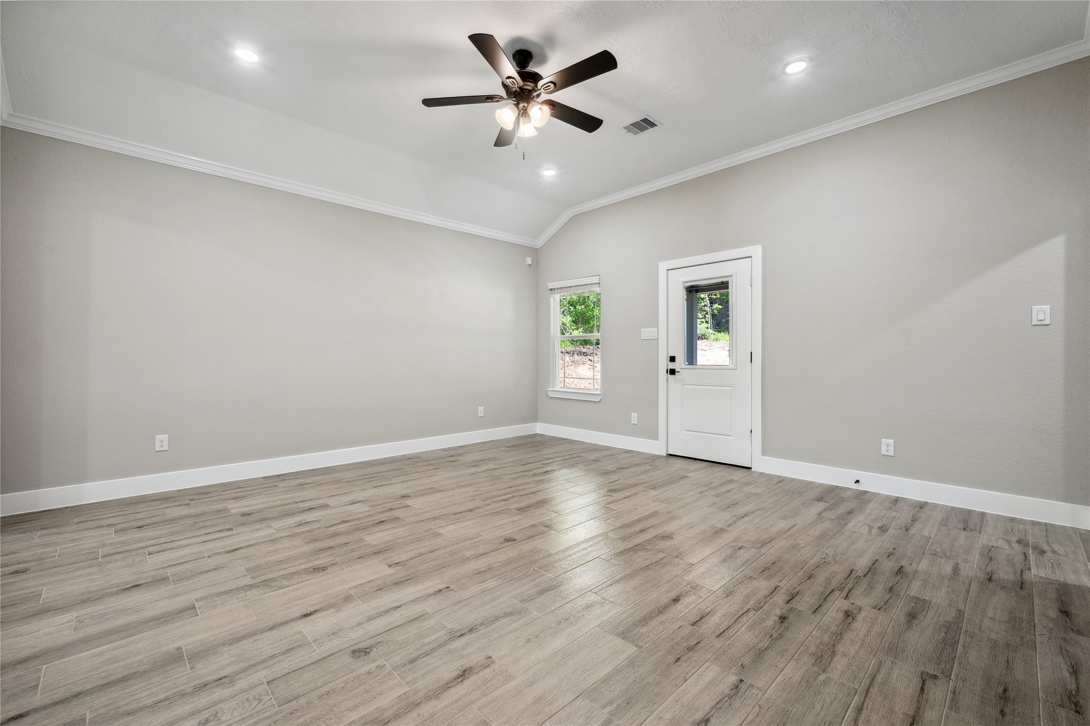 139 Popular Street Onalaska, TX 77360 - Photo 9 of 24 an empty room with wooden floor and windows