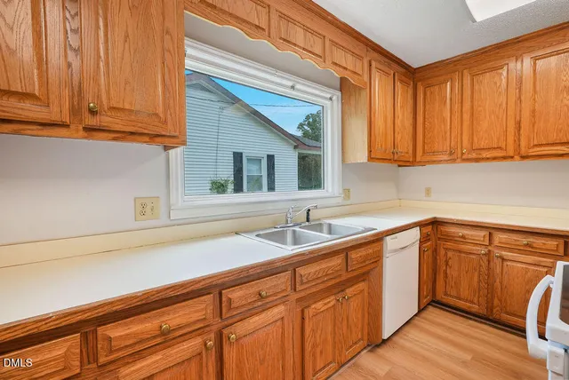 a kitchen with a sink cabinets and wooden floor