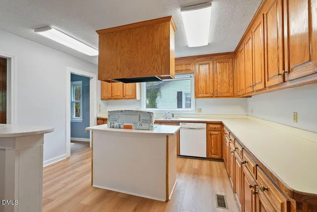 a kitchen with stainless steel appliances a sink cabinets and wooden floor