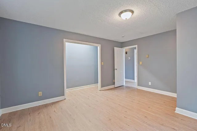 a view of an empty room with a window and closet area
