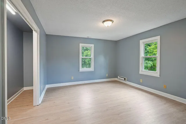 an empty room with windows and closet