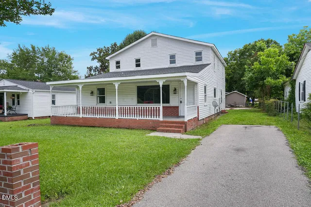 a view of house with yard and green space
