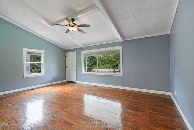 a view of a livingroom with a window and wooden floor