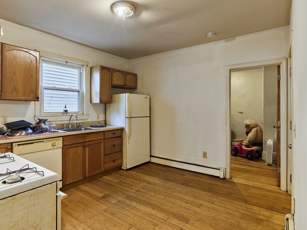 455 Washington Street Haverhill, MA 01832 - Photo 24 of 42 a kitchen with sink a refrigerator and wooden cabinets