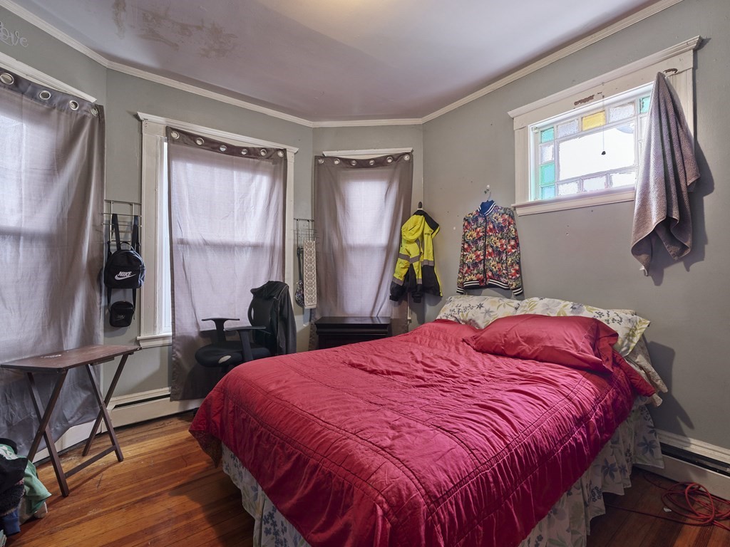 455 Washington Street Haverhill, MA 01832 - Photo 30 of 42 a bedroom with a bed and wooden floor