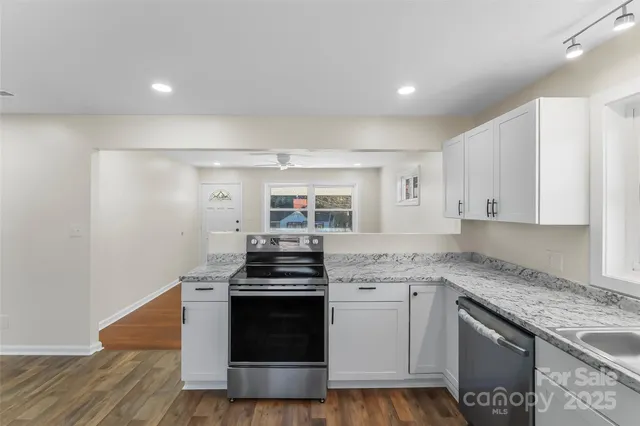 a kitchen with stainless steel appliances granite countertop a stove and a sink