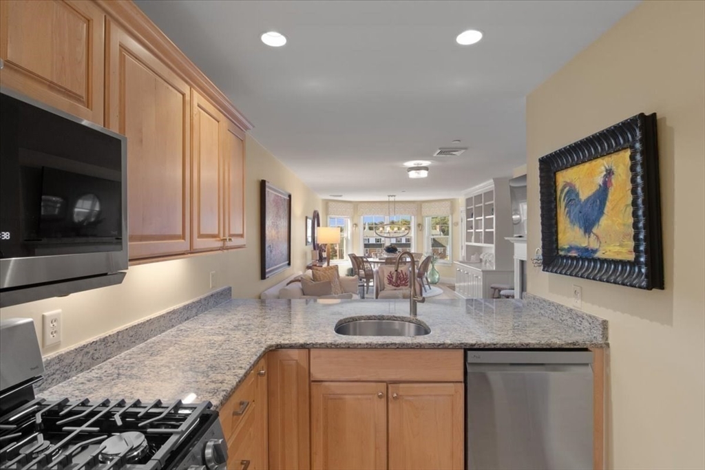 91 Front Street, Unit 308 Scituate, MA 02066 - Photo 11 of 27 a kitchen with granite countertop a sink a stove and cabinets