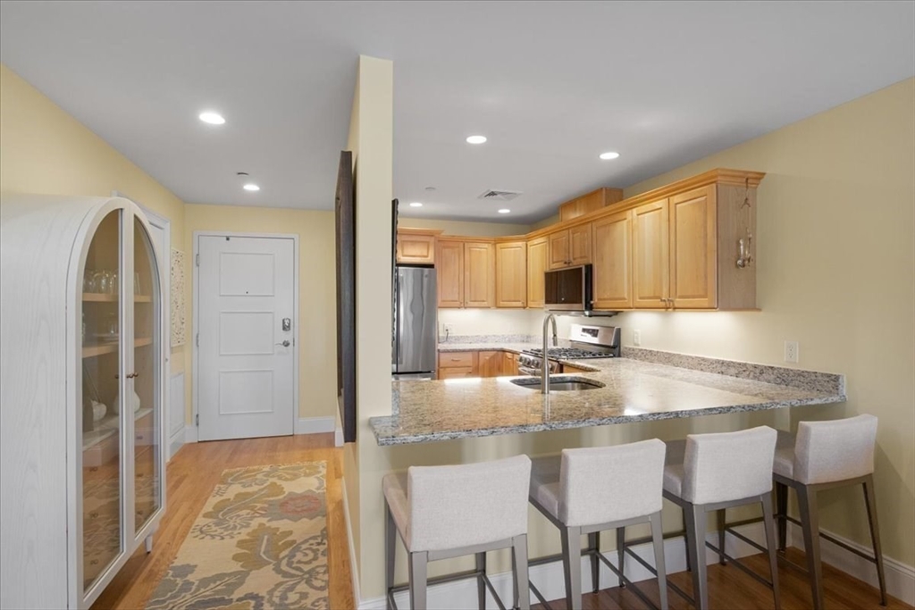 91 Front Street, Unit 308 Scituate, MA 02066 - Photo 13 of 27 a kitchen with kitchen island granite countertop a table and chairs
