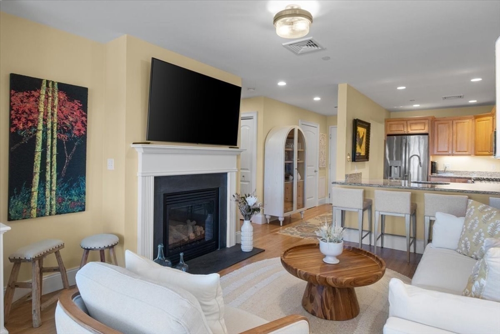 91 Front Street, Unit 308 Scituate, MA 02066 - Photo 15 of 27 a living room with furniture a flat screen tv and a fireplace