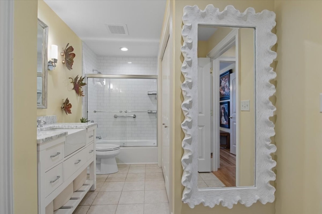 91 Front Street, Unit 308 Scituate, MA 02066 - Photo 22 of 27 a bathroom with a granite countertop sink a mirror and a shower
