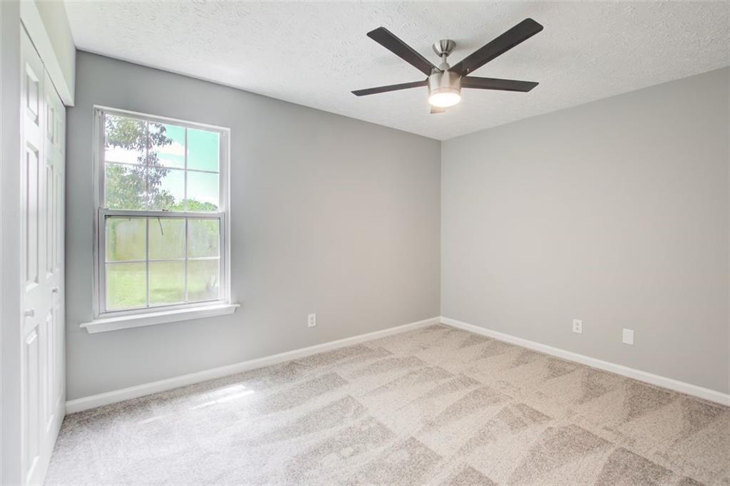 4110 Ridgebrook Bend Cumming, GA 30028 - Photo 37 of 49 an empty room with a window and a ceiling fan