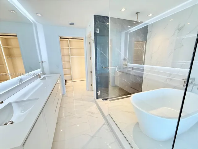 a bathroom with a double vanity sink a toilet and a tub