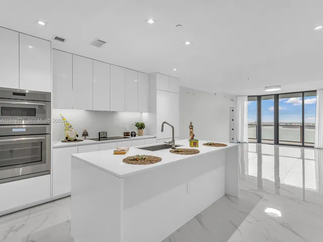 a view of a kitchen with white cabinets and a refrigerator