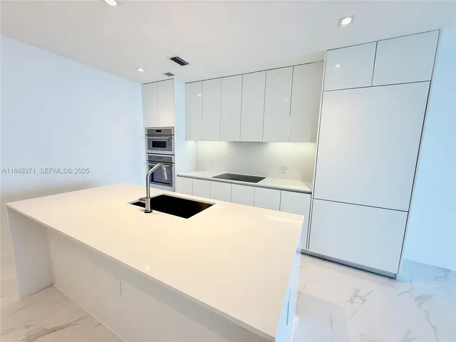 a kitchen with a sink a stove and a microwave